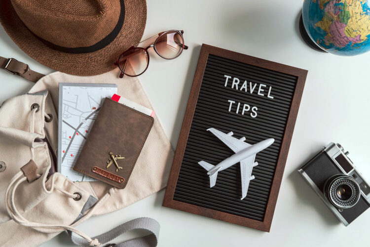 un cartel de consejos de viaje junto a accesorios habituales en los viajes de turismo