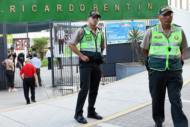 Dos policías refuerzan la seguridad en el acceso a una institución educativa en el distrito limeño de Rimac.