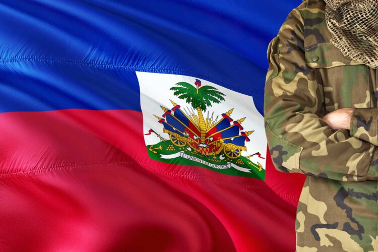 un militar junto a una bandera de Haití
