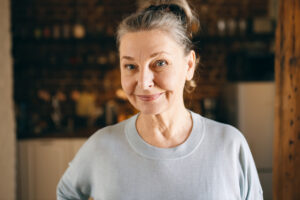 mujer mediana edad sonriente jersey gris